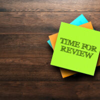 Time For Review, the phrase is written on multi-colored stickers, on a brown wooden background. Business concept, strategy, plan, planning.