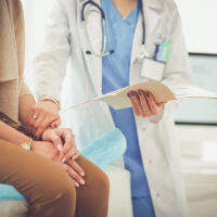 Doctor and patient discussing something while sitting at the table . Medicine and health care concept. Doctor and patient