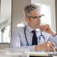 Mature doctor working in contemporary office Mature doctor working in contemporary office