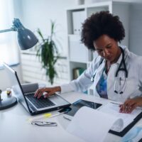 Woman doctor with stethoscope looking at medical papers at her office working hard Woman doctor with stethoscope looking at medical papers at her office working hard
